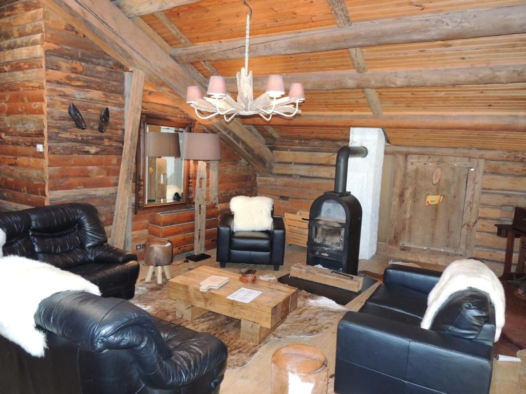 a living room with leather furniture and a fireplace at La Bournerie in Le Grand-Bornand
