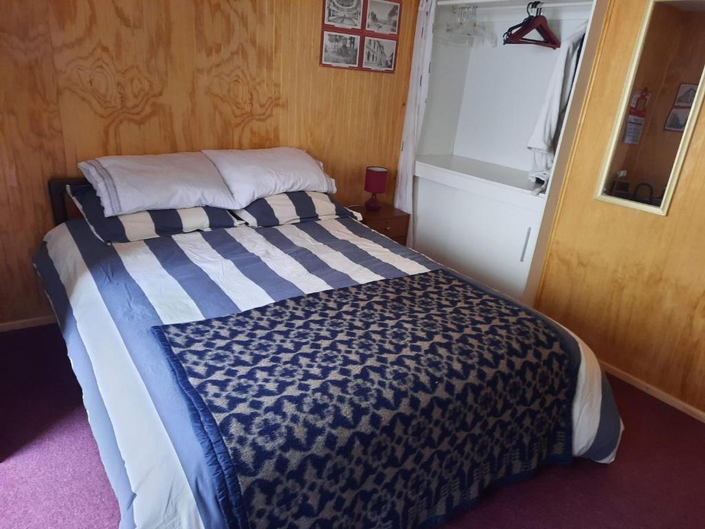 a bedroom with a bed with a blue and white comforter at Victor-alojamientos in La Serena