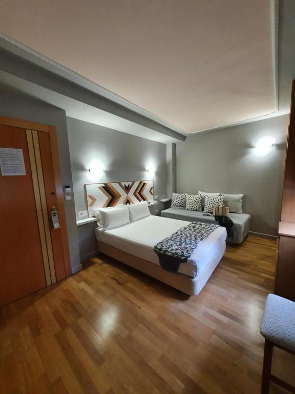 Habitación con cama y sofá. en Hotel La Cuesta, en Tapia de Casariego