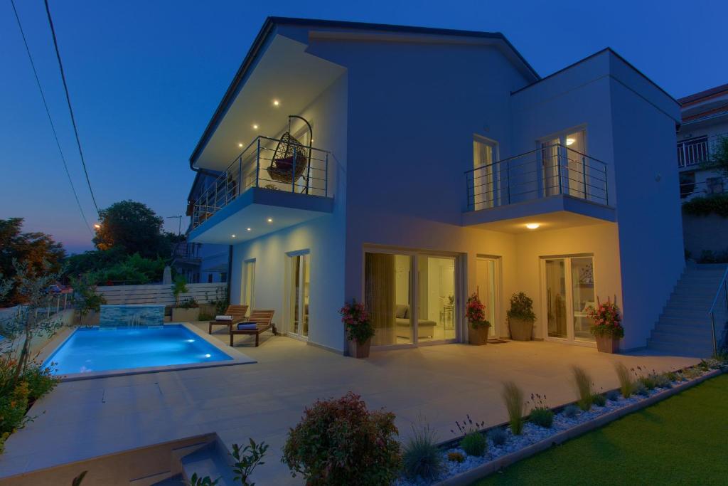 ein großes weißes Haus mit einem Pool in der Unterkunft Villa Hedera in Dramalj