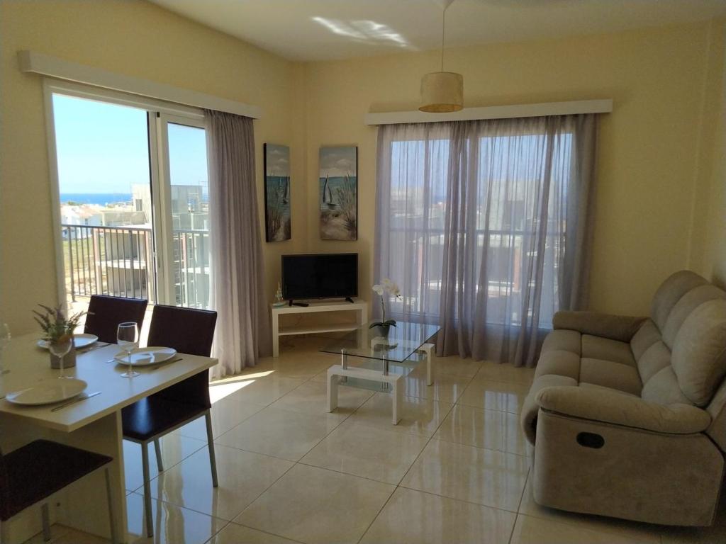 a living room with a couch and a table at Adalena Court in Paralimni