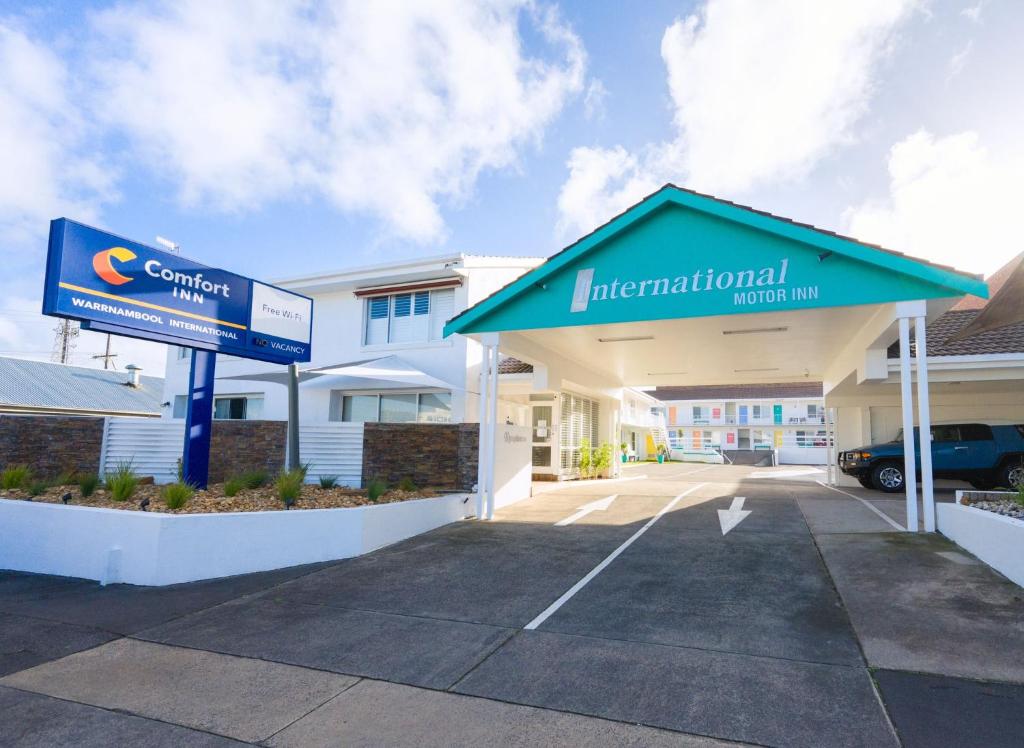 a car dealership with a sign in front of a building at Comfort Inn Warrnambool International in Warrnambool