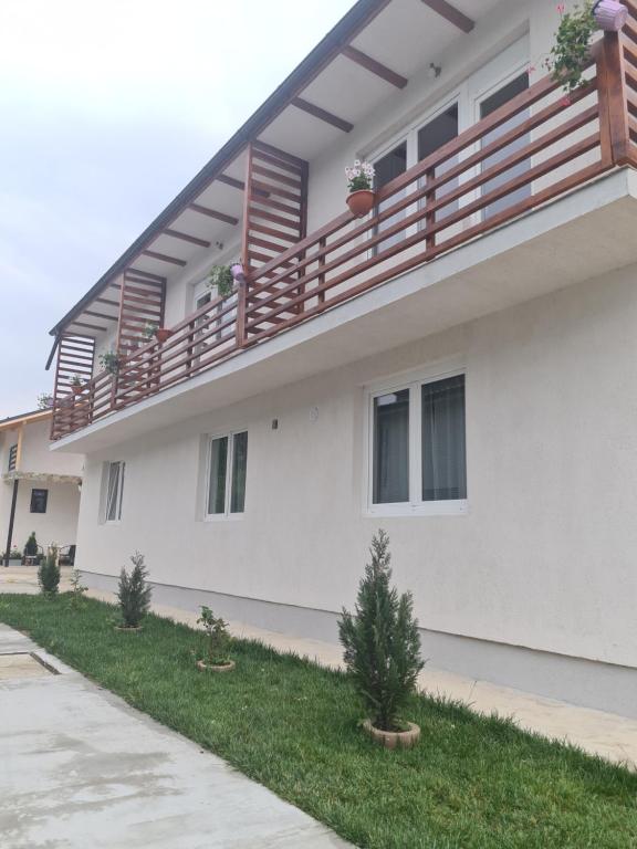 a white house with a balcony on the side of it at Luca's studio 2 ,Close to Therme Bucharest, Airport Otopeni in Baloteşti