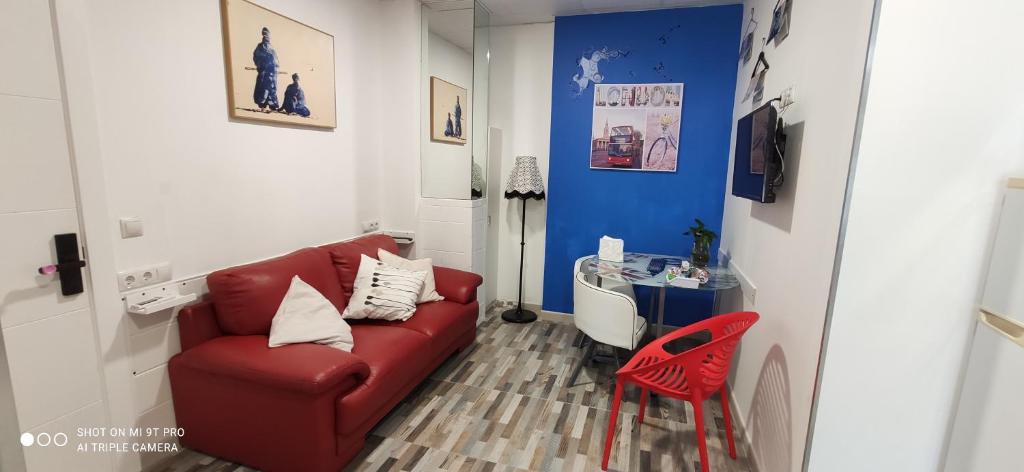 a living room with a red couch and a red chair at Huelintown in Málaga