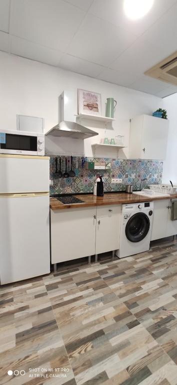 a kitchen with white cabinets and a washing machine at Huelintown in Málaga