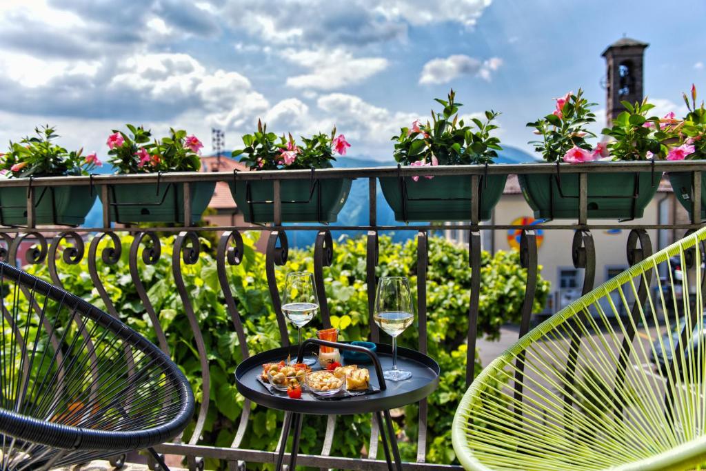 - une table avec des verres à vin et de la nourriture sur le balcon dans l'établissement Salotto Brè - Bed & Breakfast charming rooms, à Lugano