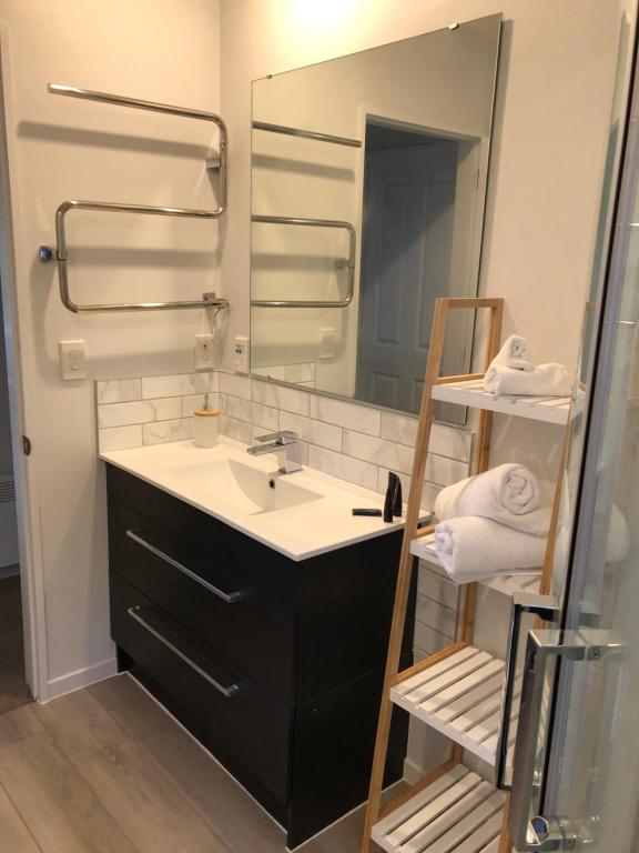 a bathroom with a sink and a mirror at Cherrywood Cottage in Akaroa