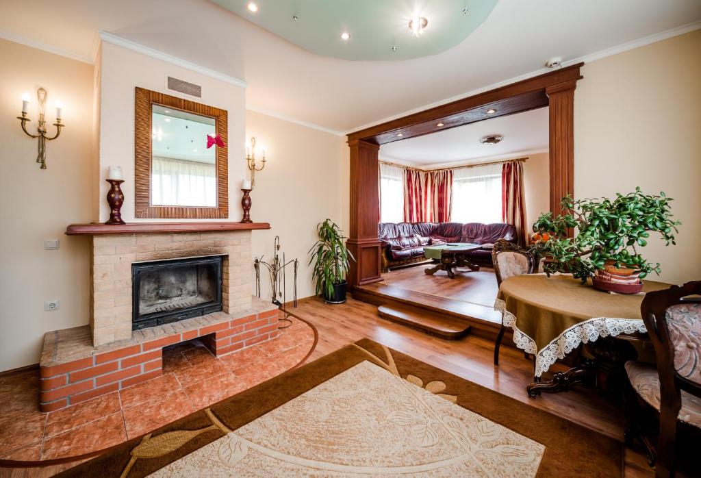 a living room with a fireplace and a table at Villa Riga in Mārupe