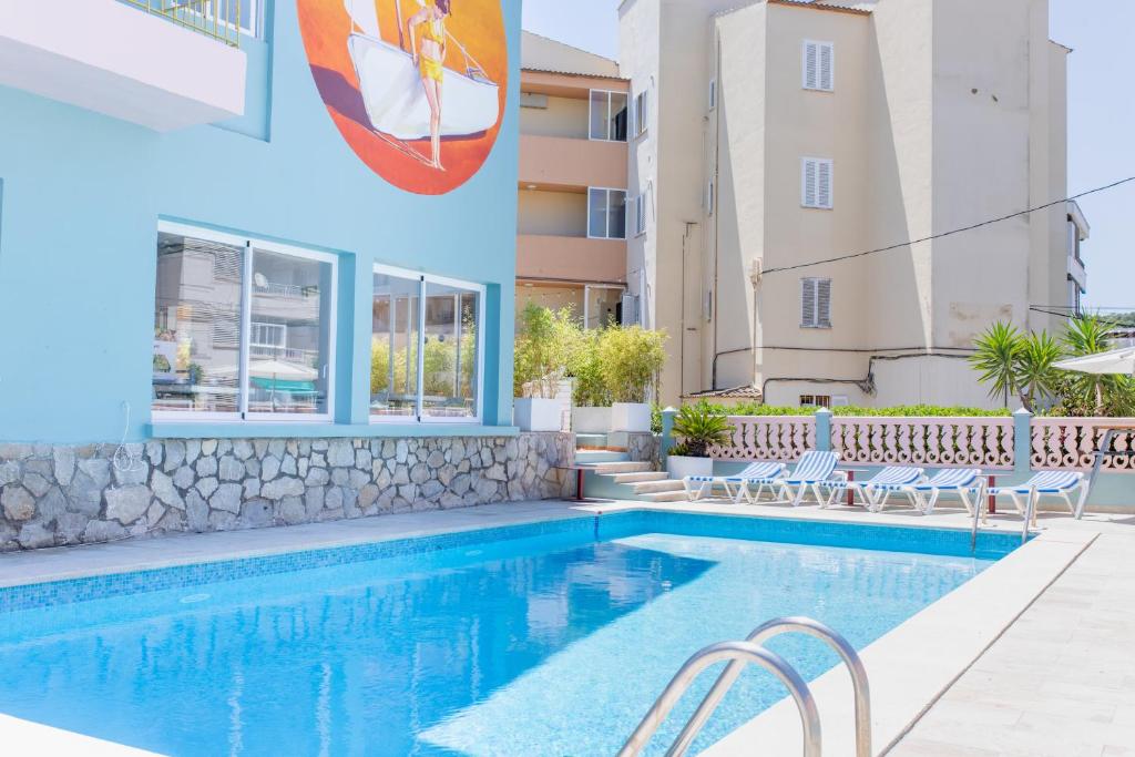 ein Pool in einem Hotel mit Stühlen und einem Gebäude in der Unterkunft 4U Miranda - Adults Only in Santa Ponsa