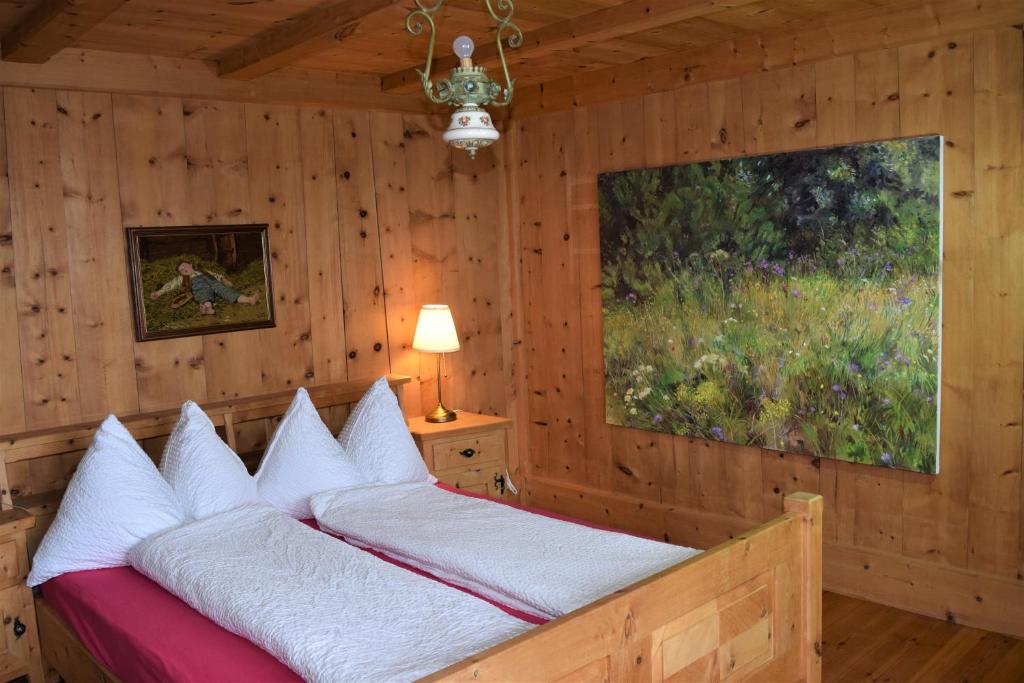 Schlafzimmer mit einem Bett mit Wandgemälde in der Unterkunft Chasa Sassalba in Lü