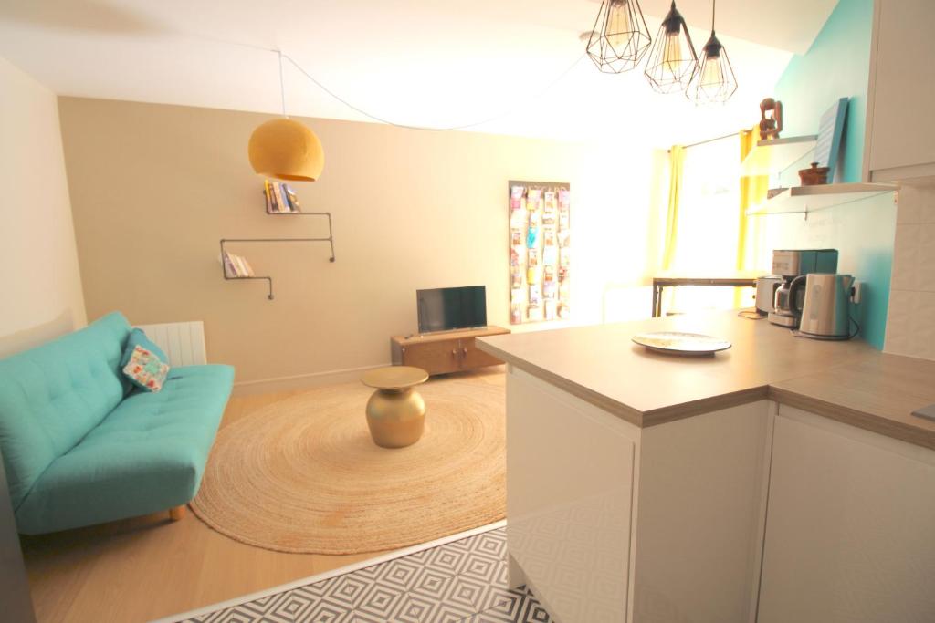 a kitchen with a counter and a blue couch in a room at Mon Appart A VILLON-MONPLAISIR in Lyon