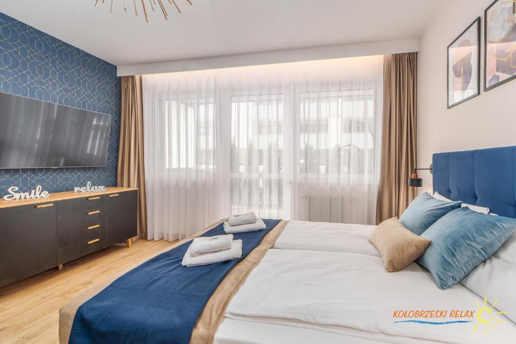 科沃布熱格的住宿－Apartament Kołobrzeski Relax，一间卧室配有一张大床和电视