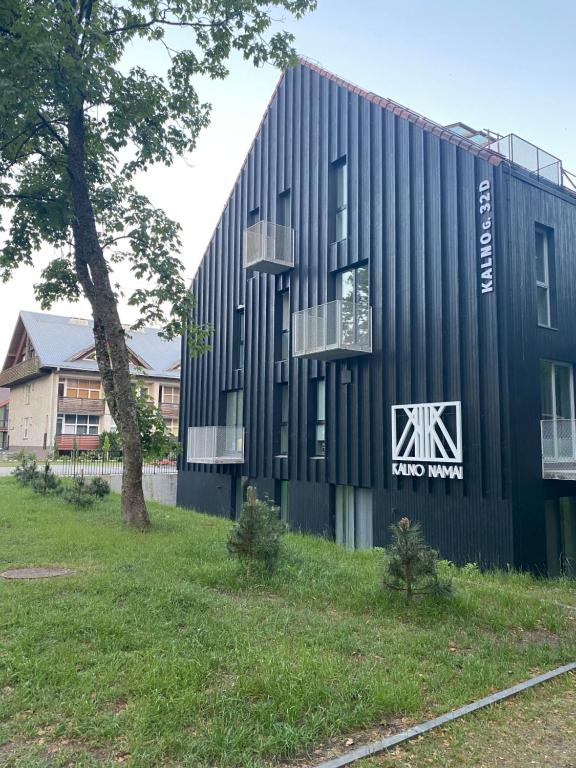 a black building with a sign on the side of it at Apartamentai '55' in Juodkrantė
