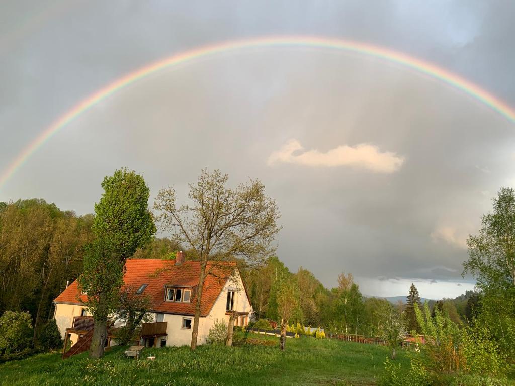 a rainbow over a house in a field at Agroturystyka Zacisze in Maciejowiec