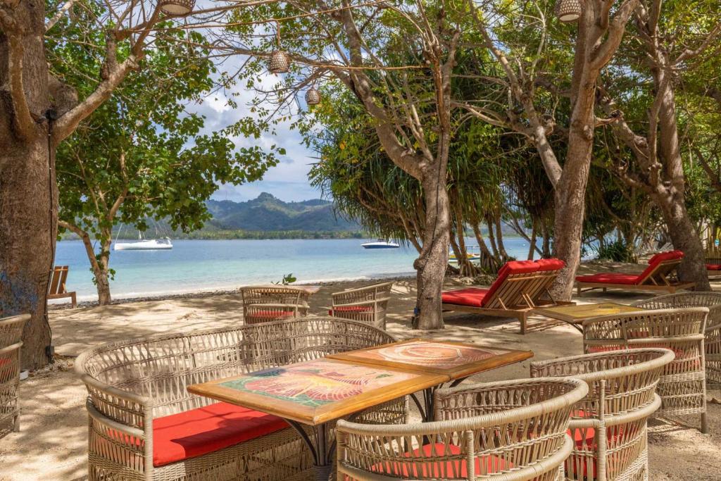 阿薩漢島的住宿－Amahelia Luxury Resort & Restaurant - Gili Asahan，一张桌子和椅子,享有水景