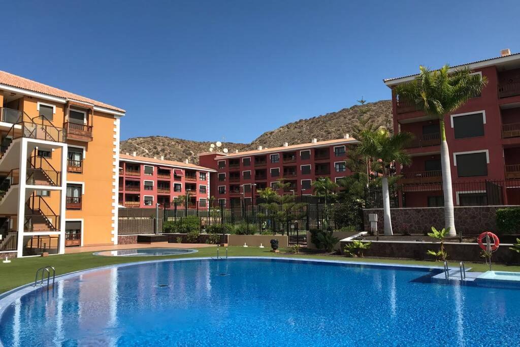 Una gran piscina frente a unos edificios. en Casa Reinhart sehr schönes Apartment um Teneriffa zu erkunden, en Palm-mar