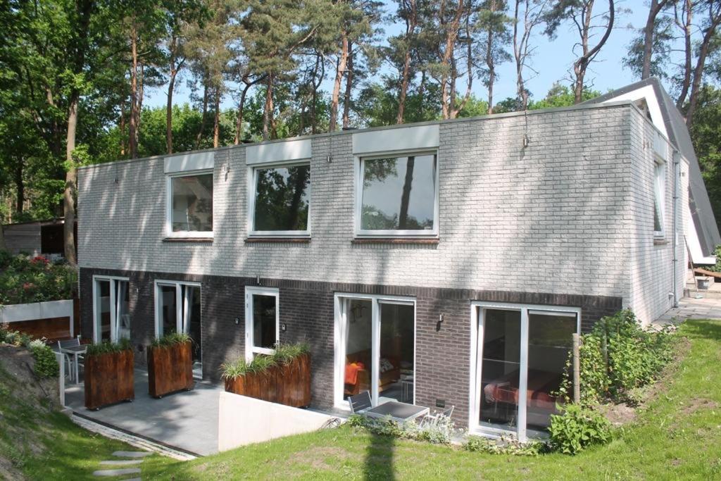 a house with a gray roof and windows at B&B 't Onderkomen in 't Harde