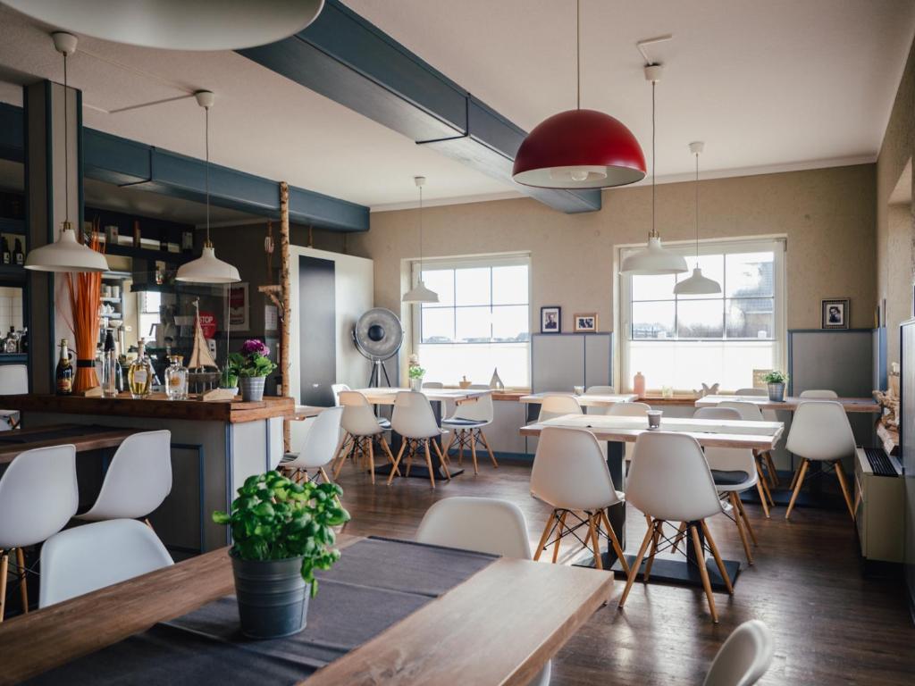 un restaurante con mesas y sillas y un bar en Seaside 26, en Friedrichskoog