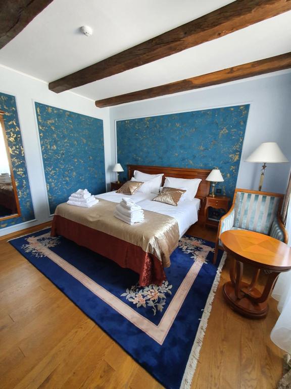 a bedroom with a bed and a blue wall at Hotel Dvorac Jurjevec in Lekenik