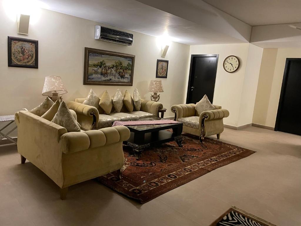 ein Wohnzimmer mit 2 Sofas und einem Tisch in der Unterkunft Royal Two Bed Room Luxury Apartment Gulberg in Lahore