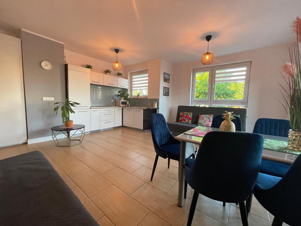 a living room with a table and chairs and a kitchen at Villa Nord in Jastrzębia Góra