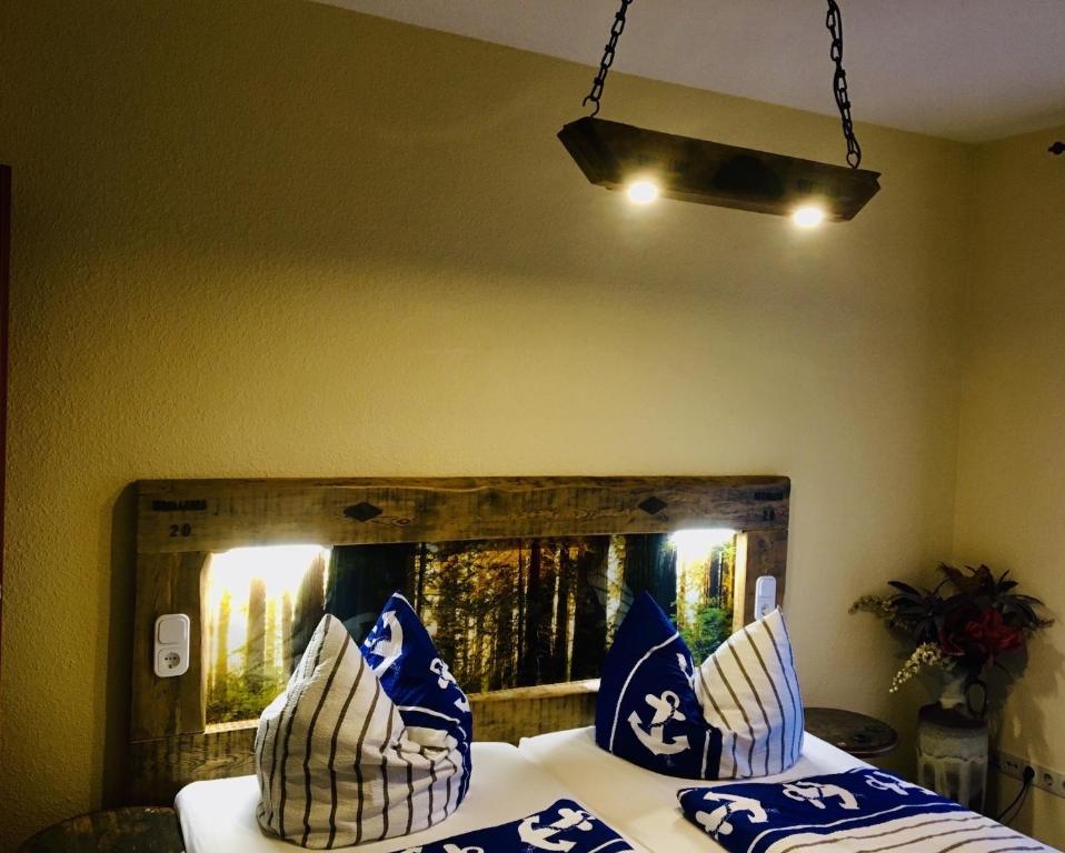 a bedroom with a bed with blue and white pillows at Ankerbräu Ferienwohnungen Brauerei Bierbad in Steinach