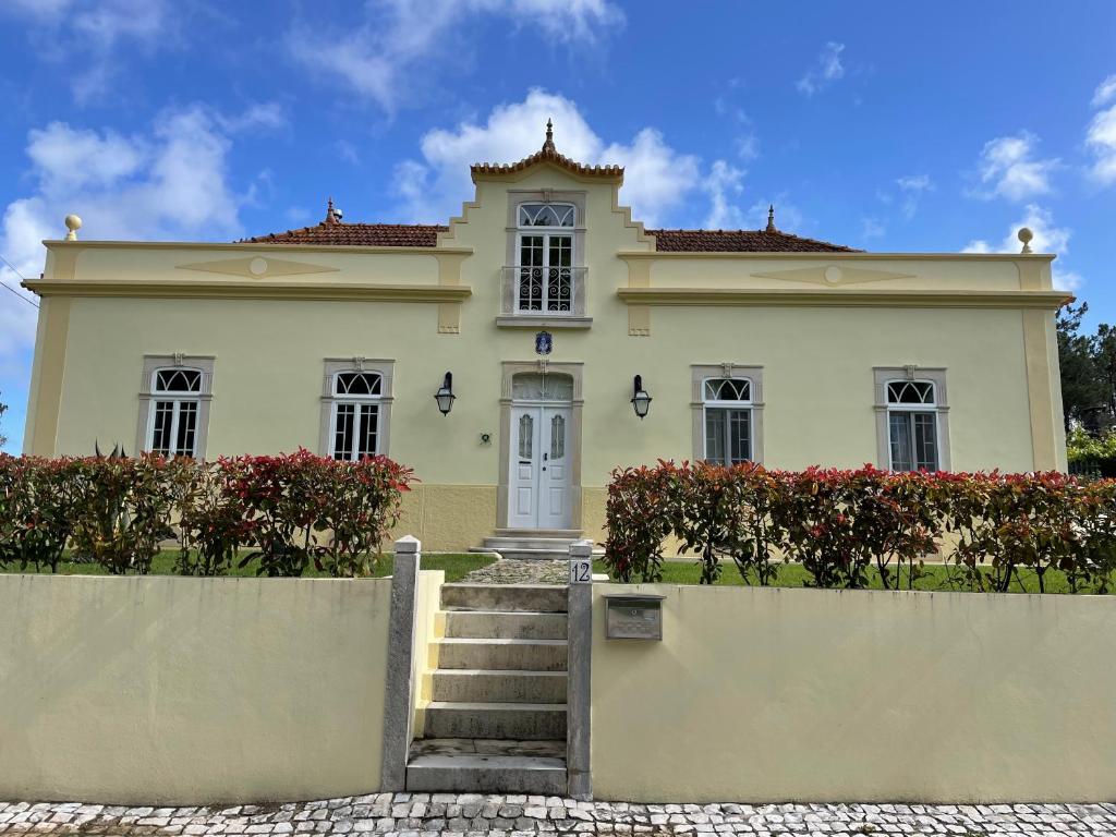 une grande maison blanche avec des escaliers en face de celle-ci dans l'établissement Casa Águas Mansas, à Cadima