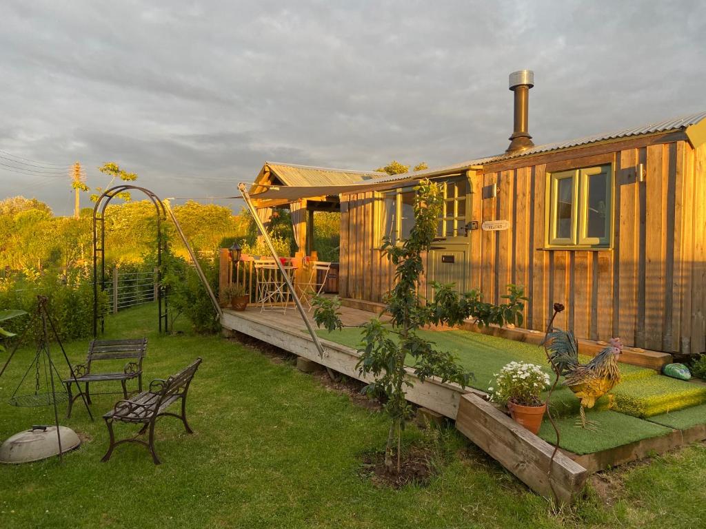 Casa de madera con patio trasero con parque infantil en Willowbank shepherds hut en Taunton