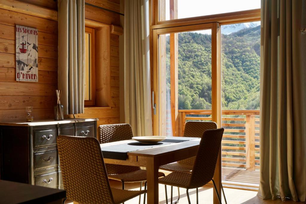 uma sala de jantar com mesa e cadeiras e uma grande janela em Alpi Azzurre em Limone Piemonte