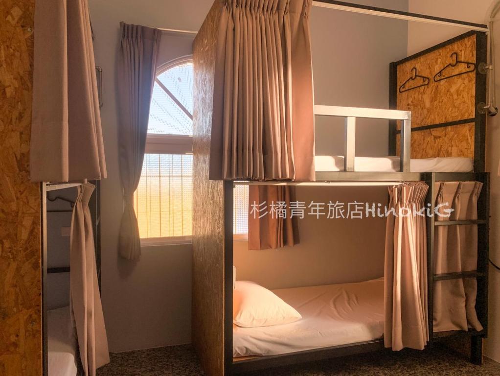 2 łóżka piętrowe w pokoju z oknem w obiekcie Liuqiu Hostel 杉橘青年旅店 w mieście Xiao Liuqiu