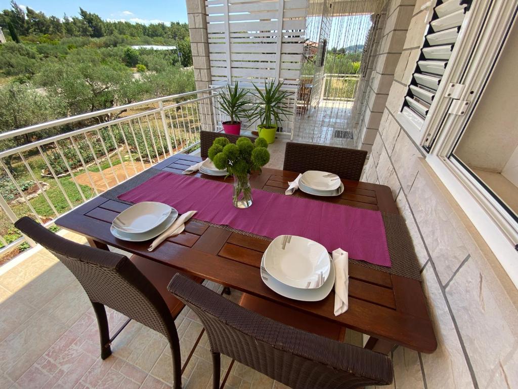 stół jadalny z krzesłami i balkon w obiekcie Villa Laguna w mieście Lumbarda