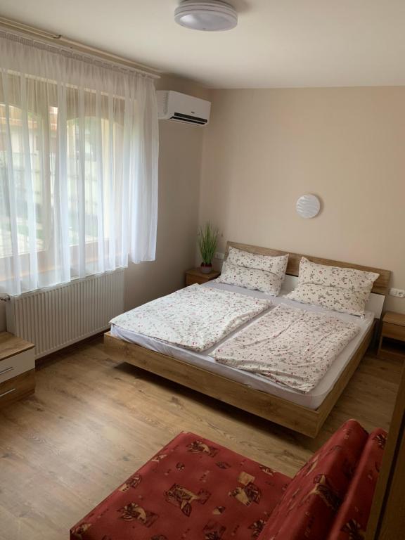 Un dormitorio con una cama y una ventana grande. en Zsuzsa Apartman Hajdúszoboszló, en Hajdúszoboszló