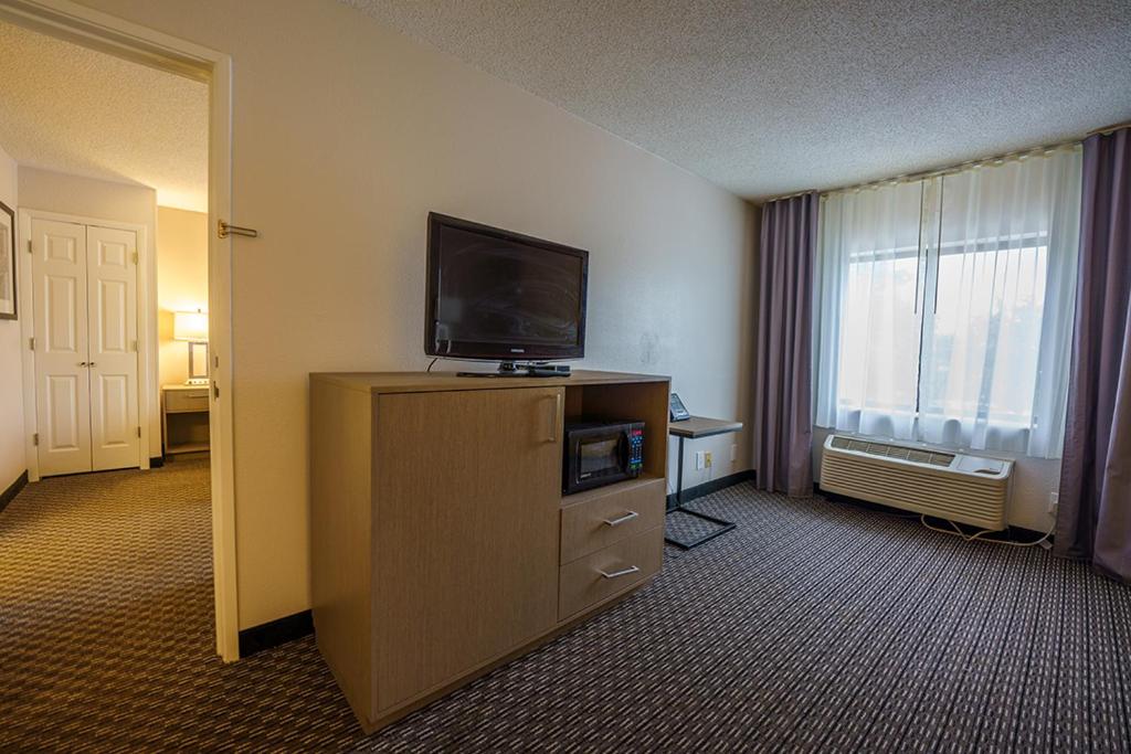 a hotel room with a television on a dresser at Wingate by Wyndham Brunswick GA I-95 in Brunswick