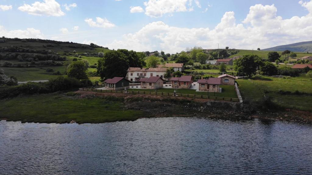 eine Luftansicht eines Hauses neben einem Wasserkörper in der Unterkunft EL CARLOTO in La Población