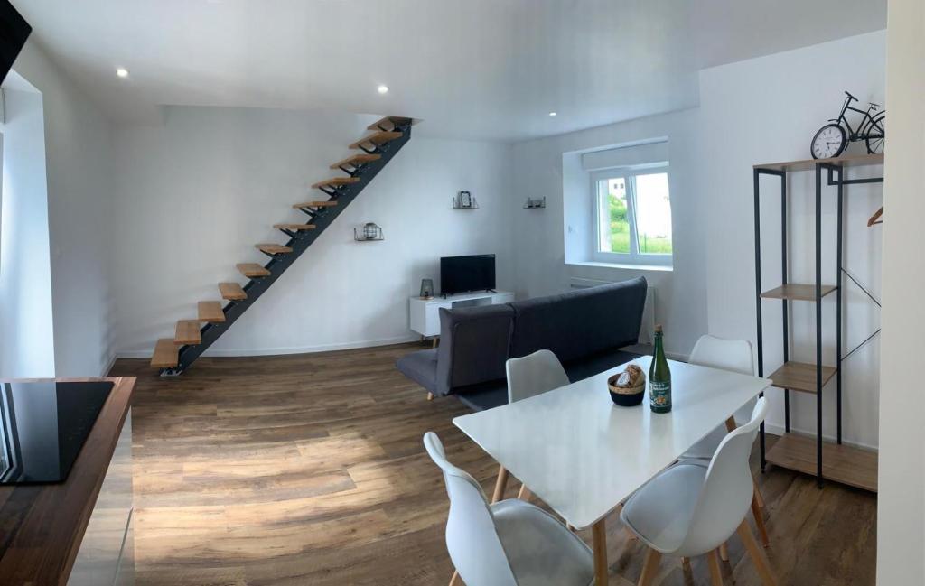 a living room with a table and chairs and a staircase at Duplex calme et cosy II in Concarneau