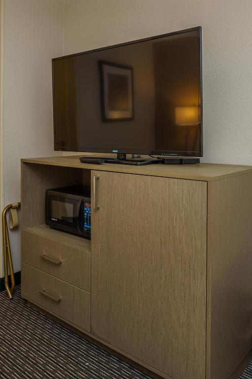 a television on top of a cabinet with a microwave at Wingate by Wyndham Brunswick GA I-95 in Brunswick