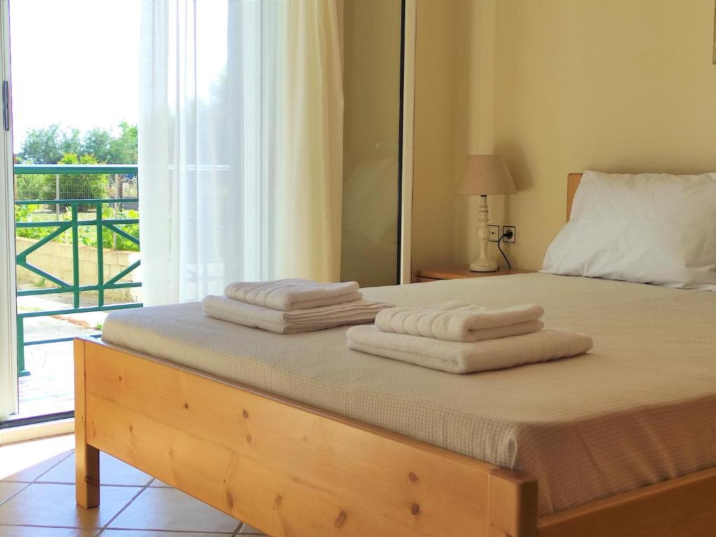 a bedroom with a bed with towels on it at Oikia Dinachris in Agios Georgios