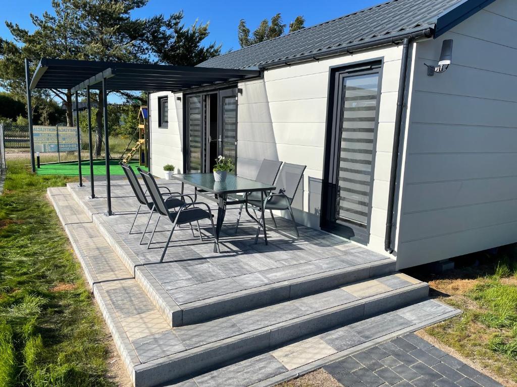 a deck with a table and chairs on a tiny house at Premium Home Rozewie in Władysławowo