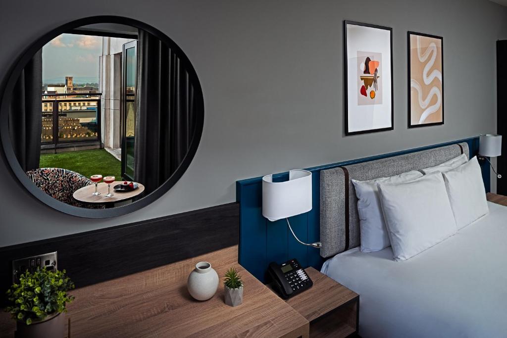 1 dormitorio con cama, espejo y mesa en George Limerick Hotel en Limerick