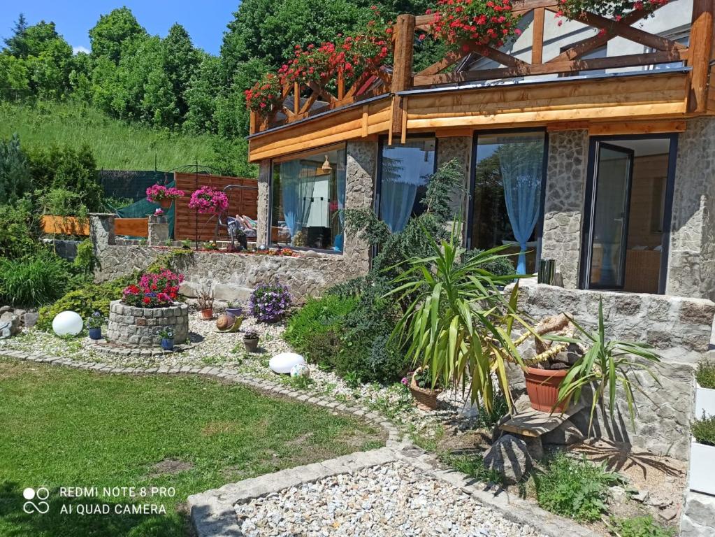 um jardim em frente a uma casa com plantas e flores em Apartamenty Sowianka em Ludwikowice Kłodzkie