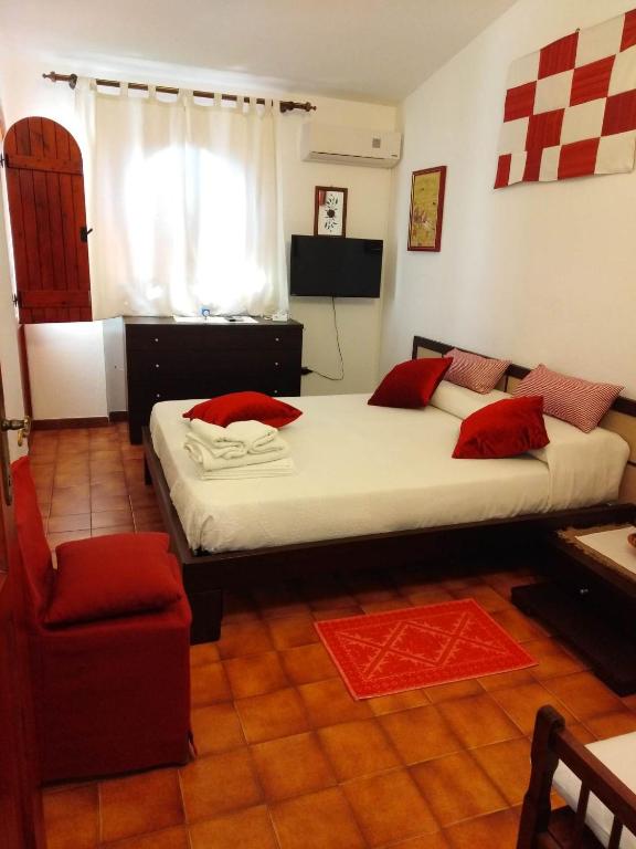 a bedroom with a large bed and a chair at Daddos in Flumini di Quartu
