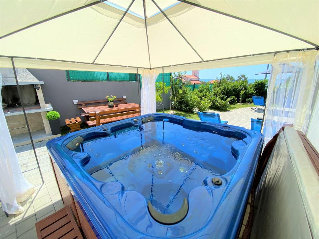 a large blue tub sitting under an umbrella at Lux Apartment Školjka in Makarska