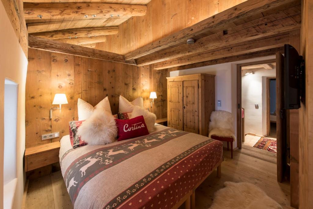 a bedroom with a large bed with wooden walls at Luxury Cortina in Cortina dʼAmpezzo