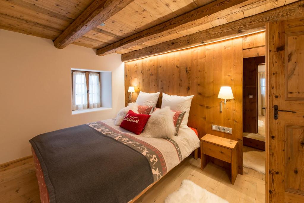 a bedroom with a bed and a wooden wall at Luxury Cortina in Cortina dʼAmpezzo