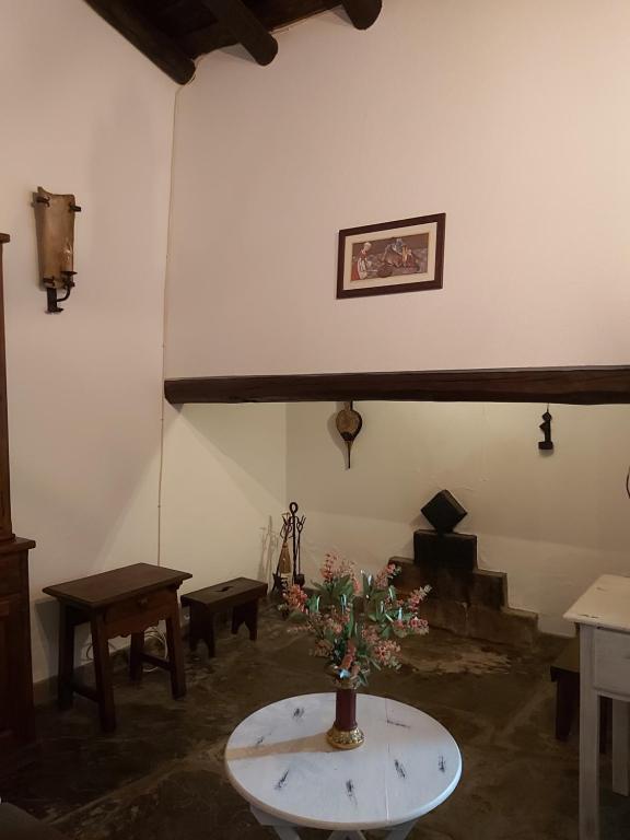 Una habitación con una mesa con un jarrón de flores. en Casa da Avó Velhinha, en Telheiro