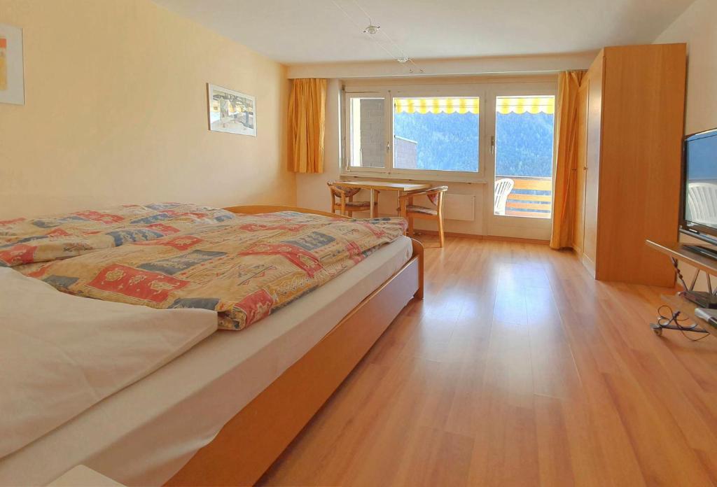 una camera con letto, tavolo e TV di Serviced Apartments Wallis a Mörel