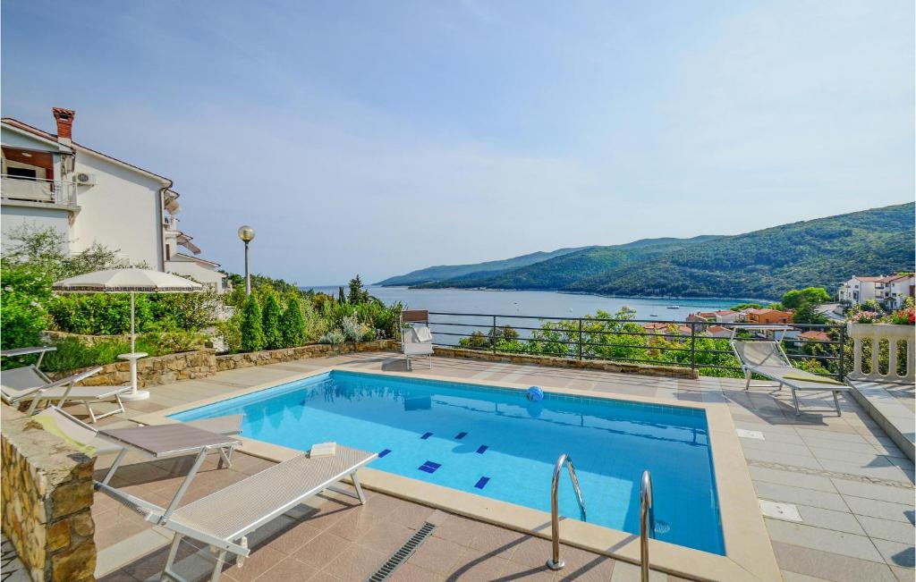 a swimming pool with a view of the water at Beautiful Home In Rabac With House Sea View in Rabac