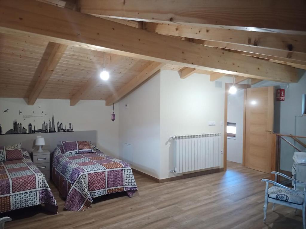 two beds in a room with wooden ceilings at Casa El Pastor in Valcovero