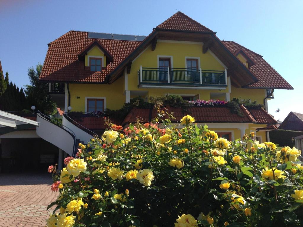 ein gelbes Haus mit Blumen davor in der Unterkunft Haus Rose in Wenigzell