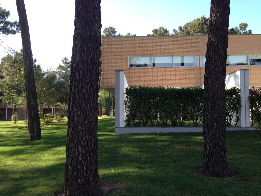 um edifício de tijolos com árvores em frente em Barca Golf House em Esposende